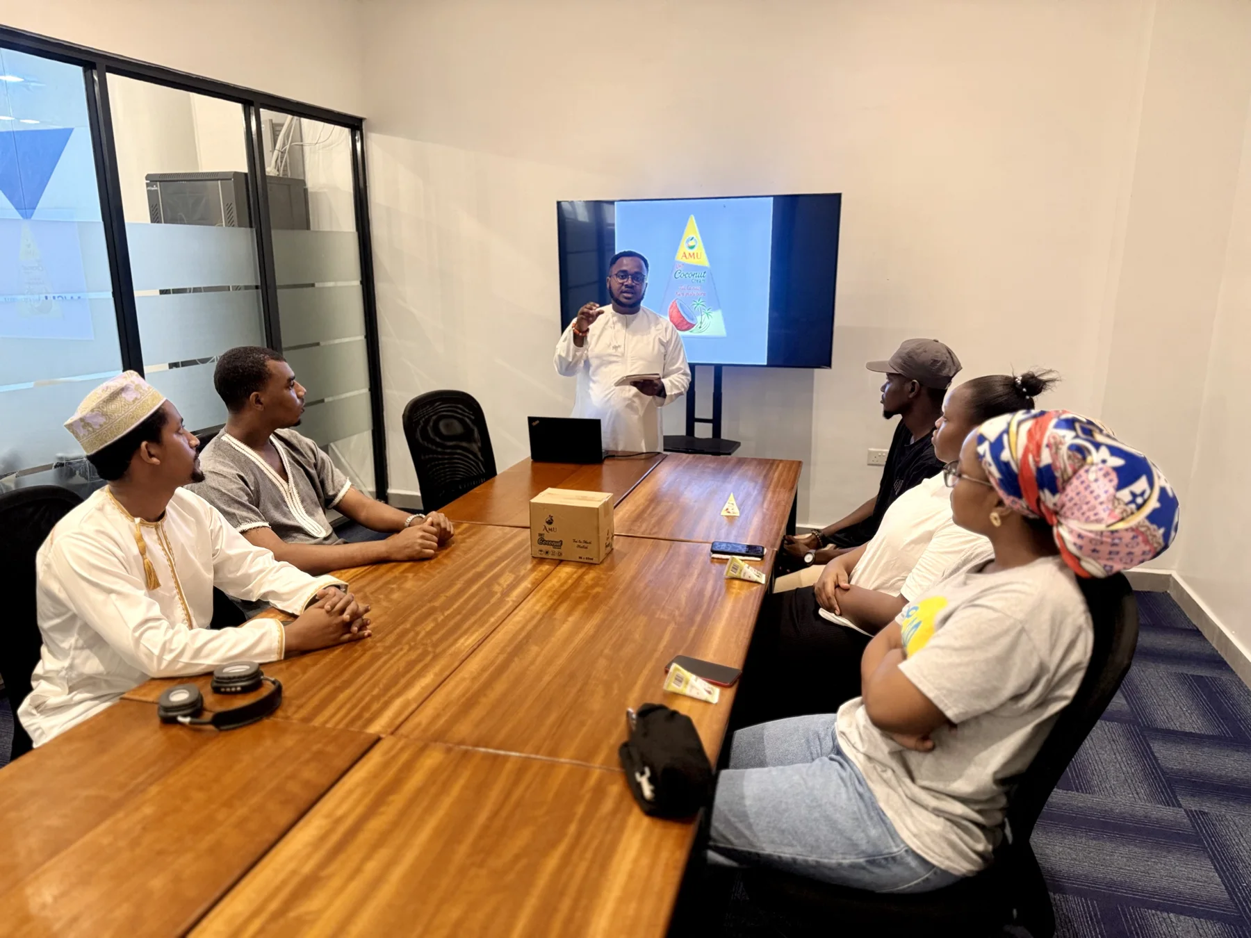 Team members attending an Amu product-knowledge presentation around a meeting table